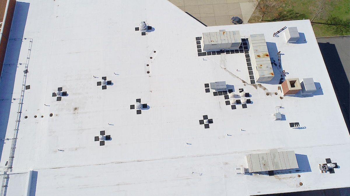 Aerial view of residential roof being measured for cost estimation